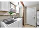 Efficient laundry room with modern appliances, wooden beam accent, and ample storage space, perfect for organization at 316 Jenkins Ave, Brooksville, FL 34604
