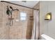 Close-up of a tiled shower with an adjustable shower head and built-in shelves for storage at 316 Jenkins Ave, Brooksville, FL 34604