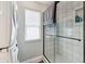 This bathroom features a glass shower with marble tiling and a stacked washer and dryer set at 3285 Minnow Creek Dr, Hernando Beach, FL 34607
