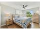 This bedroom features a queen-size bed, ceiling fan, hardwood floors, and natural light at 3285 Minnow Creek Dr, Hernando Beach, FL 34607