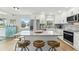 Bright kitchen with island seating, white cabinets, stainless appliances, and tile backsplash at 3285 Minnow Creek Dr, Hernando Beach, FL 34607