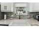 Close up of farmhouse sink with view of palm trees from kitchen window at 3285 Minnow Creek Dr, Hernando Beach, FL 34607