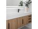 Bathroom vanity with a modern sink, wood cabinets, black hardware, and an illuminated mirror at 3344 Lagoy St, North Port, FL 34291