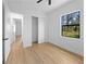 Bright bedroom with wood-look floors, closet, ceiling fan, and a scenic window view at 3344 Lagoy St, North Port, FL 34291