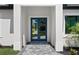 Front entrance with gray stone tile walkway and bright blue double doors framed by white columns at 3344 Lagoy St, North Port, FL 34291