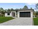 Modern home with a paver driveway and well-maintained lawn at 3344 Lagoy St, North Port, FL 34291