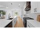 Open kitchen with a granite island, a black faucet and stainless steel appliances at 3344 Lagoy St, North Port, FL 34291