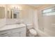 Bright bathroom featuring a large mirror, vanity with storage, and a shower-tub combo at 3404 Dahlia Pl, Largo, FL 33771