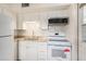 Newly remodeled kitchen featuring modern white appliances, countertops, and backsplash at 3404 Dahlia Pl, Largo, FL 33771