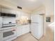 Well-lit kitchen featuring white appliances, granite countertops, and tile backsplash at 3404 Dahlia Pl, Largo, FL 33771