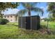 A sturdy metal shed is on a grassy area with a palm tree at 3404 Dahlia Pl, Largo, FL 33771