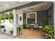 Inviting front porch with neutral tiling, hanging plants, and comfortable seating creates a cozy outdoor space at 3414 Whittier St, Tampa, FL 33619