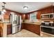 Bright kitchen featuring stainless steel appliances, granite countertops, and dark wood cabinetry with a tiled floor at 3414 Whittier St, Tampa, FL 33619