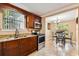 Galley kitchen features stainless steel appliances, granite countertops, and dark wood cabinetry with an adjacent dining area at 3414 Whittier St, Tampa, FL 33619