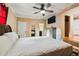 Spacious main bedroom with a ceiling fan, a view of the en suite bathroom, and hardwood floors at 3414 Whittier St, Tampa, FL 33619