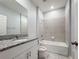 Bathroom featuring a tub with a shower, granite counter, and tiled backsplash at 34187 Rogallo Ln, Wesley Chapel, FL 33545