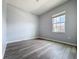 Bedroom with wood-look laminate floors, a window, and neutral paint at 34187 Rogallo Ln, Wesley Chapel, FL 33545