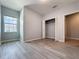 Bedroom with a window, closet, and wood-look laminate floors at 34187 Rogallo Ln, Wesley Chapel, FL 33545