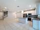 Bright kitchen with a granite island, stainless steel appliances, white cabinets and a clear view of the staircase and entry at 34187 Rogallo Ln, Wesley Chapel, FL 33545