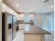 Bright, open kitchen with stainless steel appliances, granite countertops, a central island, and sleek white cabinets at 34187 Rogallo Ln, Wesley Chapel, FL 33545