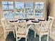 Cozy dining area with an oval table, seating for six, and scenic water views through the shuttered windows at 4103 Gulf Blvd # 210, St Pete Beach, FL 33706