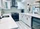 Bright kitchen featuring white cabinetry, stainless steel appliances, and sleek countertops with views of the water outside at 4103 Gulf Blvd # 210, St Pete Beach, FL 33706