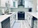 Well-lit kitchen boasts white cabinets, stainless steel appliances, elegant backsplash and gleaming counterspace at 4103 Gulf Blvd # 210, St Pete Beach, FL 33706