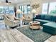 Bright living room featuring a comfortable sofa, stylish chairs, and a decorative rug on hardwood flooring at 4103 Gulf Blvd # 210, St Pete Beach, FL 33706