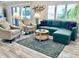 Bright living room featuring a comfortable sofa, stylish chairs, and a decorative rug on hardwood flooring at 4103 Gulf Blvd # 210, St Pete Beach, FL 33706