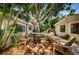 Private backyard retreat featuring a wooden deck, fire pit, hammock, and lush landscaping at 4106 W Fielder St, Tampa, FL 33611