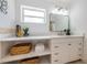 Bright bathroom features a white vanity, baskets for storage and a modern mirror at 4106 W Fielder St, Tampa, FL 33611