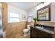 Bathroom featuring a dark wood vanity and tiled walls with a large mirror at 4106 W Fielder St, Tampa, FL 33611