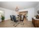 Bright dining room with glass table, black chairs, and modern lighting, opening to kitchen at 4106 W Fielder St, Tampa, FL 33611