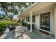 Inviting front porch with stylish seating, swing, and a charming blue door to welcome guests at 4106 W Fielder St, Tampa, FL 33611