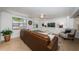 Comfortable living room featuring a large brown sofa, white ceiling, and bright natural light at 4106 W Fielder St, Tampa, FL 33611