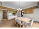 Dining room featuring wood floors with views of the kitchen with stainless steel appliances and white cabinets at 4304 N River View Ave, Tampa, FL 33607