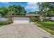 Wide brick driveway leads to a two-car garage of this lovely home with mature trees and a manicured lawn at 4304 N River View Ave, Tampa, FL 33607