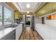 Well-lit kitchen featuring white cabinetry, stainless steel appliances, and a view into the adjacent living room at 4304 N River View Ave, Tampa, FL 33607
