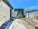Backyard with a small patio, overgrown vegetation, and an adjacent chain-link fence at 4709 Mineola St, Bradenton, FL 34207