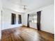 Bedroom with hardwood floors, ceiling fan, and windows dressed with dark curtains at 4709 Mineola St, Bradenton, FL 34207