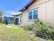 Exterior view of a home with a stucco facade, blue flowers, and a small front yard at 4709 Mineola St, Bradenton, FL 34207