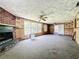Spacious living room with a brick fireplace, large windows, and carpet flooring at 4709 Mineola St, Bradenton, FL 34207