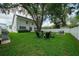 Expansive backyard with a lush lawn, mature trees, and outdoor seating areas, ideal for entertaining at 4710 W Tambay Ave, Tampa, FL 33611