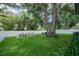 Lush backyard featuring a manicured lawn, mature trees, and inviting outdoor dining and lounging spaces at 4710 W Tambay Ave, Tampa, FL 33611