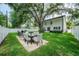 Expansive backyard with lush lawn, a concrete patio, and an outdoor dining area at 4710 W Tambay Ave, Tampa, FL 33611