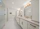 Spa-like bathroom with double sink vanity, granite counters, modern gold fixtures and a glass enclosed shower at 4710 W Tambay Ave, Tampa, FL 33611
