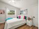 Bright bedroom with hardwood floors and a cozy bed, complemented by colorful decor for a cheerful ambiance at 4710 W Tambay Ave, Tampa, FL 33611