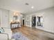 Hallway area featuring two armchairs, a console table, access to office space, and hardwood floors at 4710 W Tambay Ave, Tampa, FL 33611