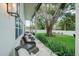 Inviting covered porch with comfortable seating, offering a peaceful view of the lush, green backyard at 4710 W Tambay Ave, Tampa, FL 33611