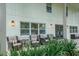 Charming covered porch with comfortable wicker seating, perfect for enjoying the view of the lush greenery at 4710 W Tambay Ave, Tampa, FL 33611